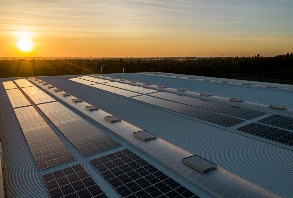 Commercial rooftop solar array catching low evening sun