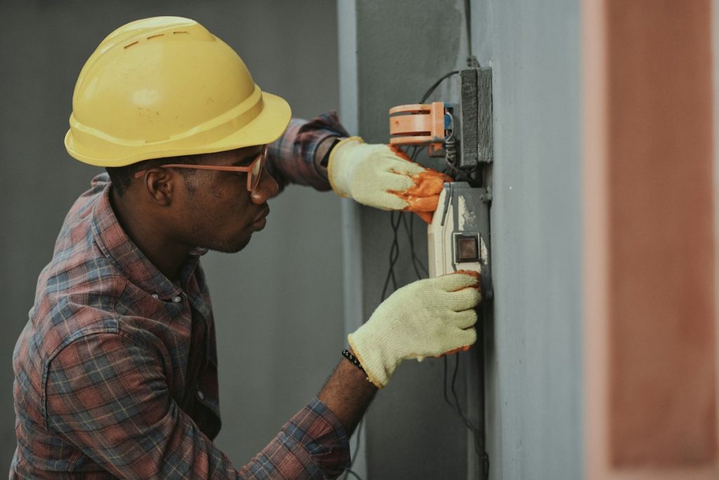 Electrician in a hard hat working on system wiring