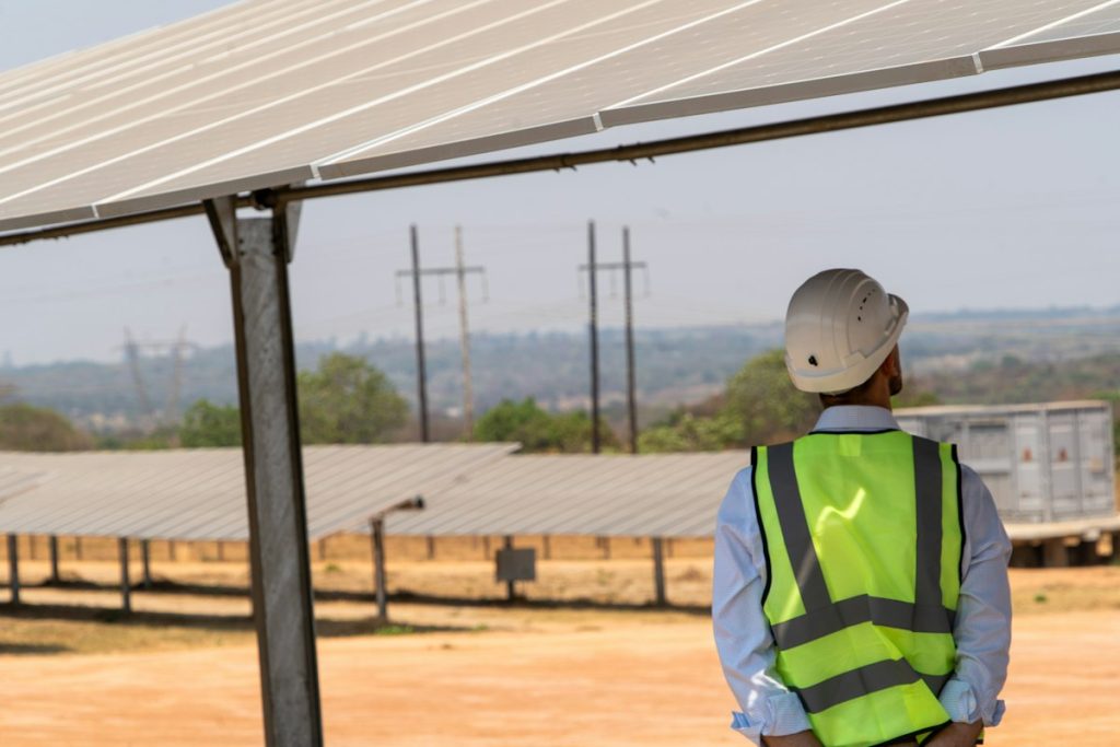 Engineer in a safety vest checking a solar mounting structure