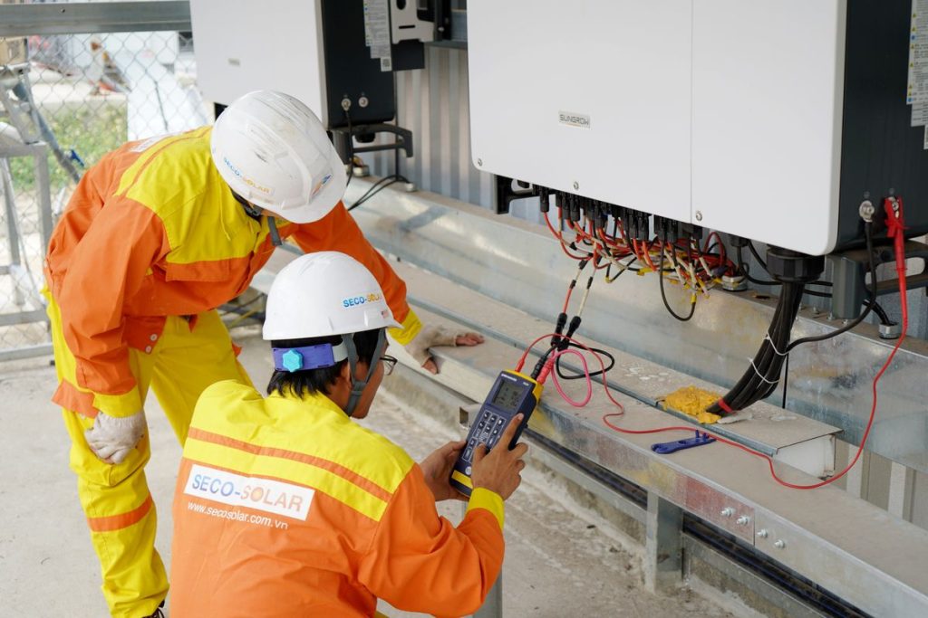Two electrical engineers testing a solar power system on site