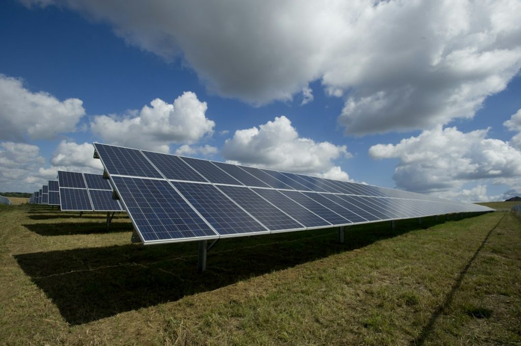 Ground-mounted solar array on a green field