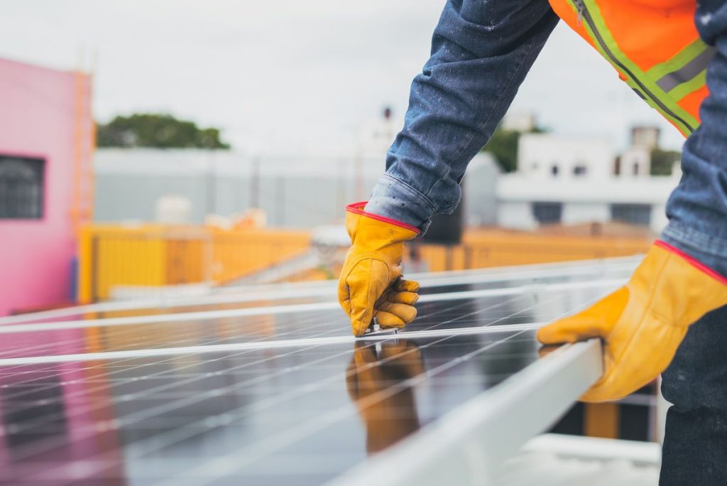 Solar technician performing maintenance on panels outdoors